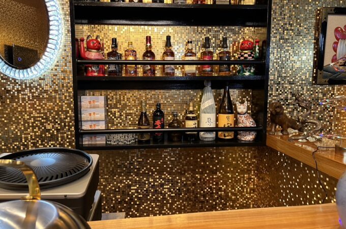 金のモザイクタイルと黒の造作酒棚を組み合わせたバーカウンター