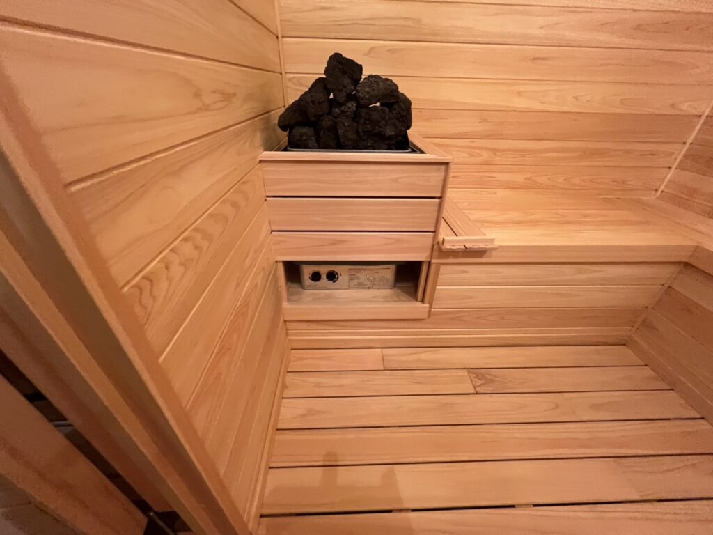 木で囲ったサウナストーブとベンチ