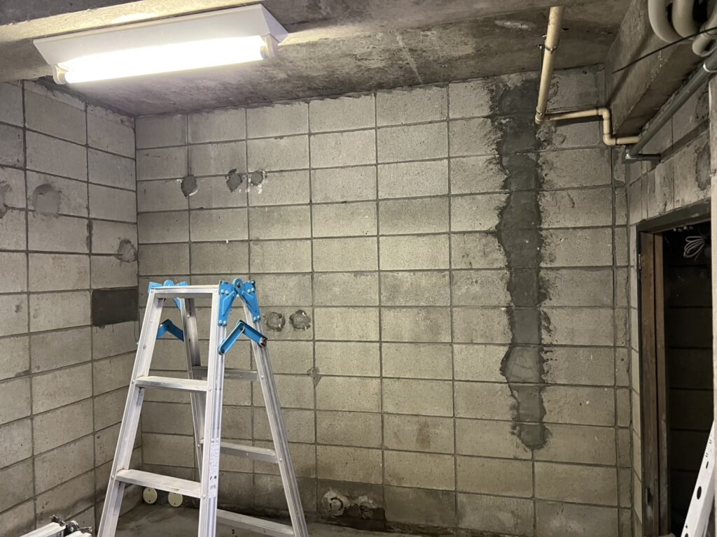 施工前の、補修跡のあるコンクリートブロックの壁と天井