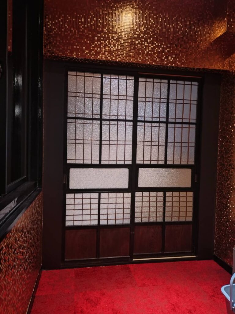 赤いカーペットのお部屋に納めた、型板ガラスの格子の引き戸