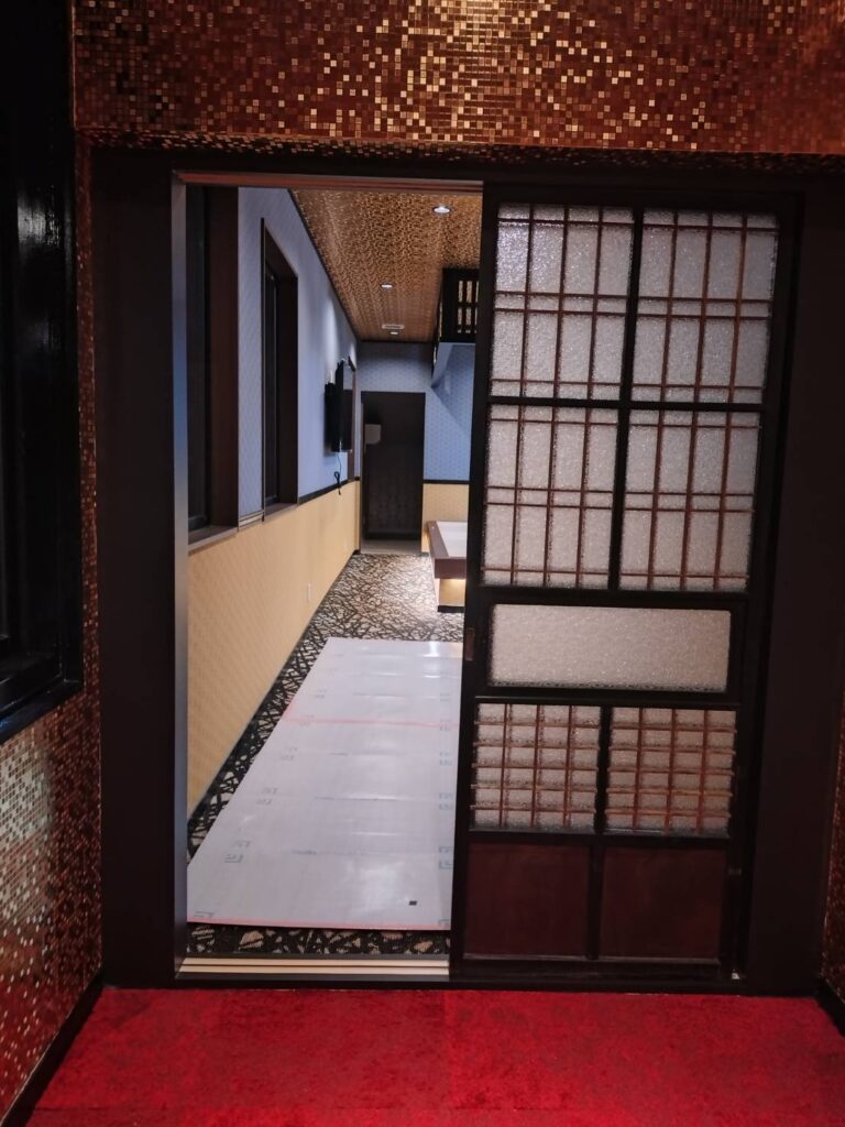 赤いお部屋から引き戸越しに見た、麻の葉柄のクロスの廊下